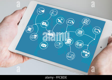 Hand holding tablet moderne. Internet des objets (IOT) modèle d'affaires avec la carte du monde sur fond bleu. Banque D'Images