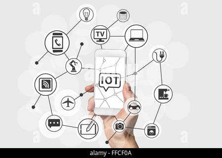 Internet des Objets (IOT) concept with hand holding blanc moderne et de l'argent smart phone. Les périphériques connectés dans le nuage Banque D'Images