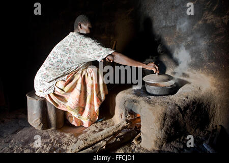 Madame Betty Okiru la cuisson dans une hutte à l'aide d'un poêle à haut rendement énergétique. La cuisinière est construit d'une façon qui utilise le moins de bois, d'une cheminée est construite à l'arrière pour enlever la fumée provenant de la cabane. Elle vit avec son mari Francis Okiru dans le district de Pallisa. Francis s'est joint au projet Kulika en 2003 et a reçu une formation d'agriculture biologique durable. Banque D'Images