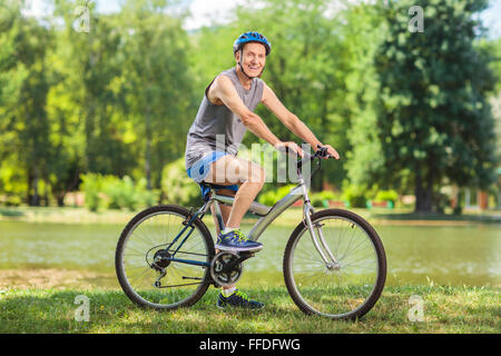 Senior homme monté sur un vélo en stationnement sur une belle journée d'action avec l'objectif de décentrement et Banque D'Images