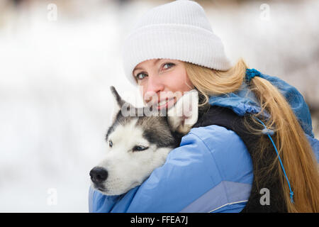 Jeune femme avec chien husky en hiver Banque D'Images