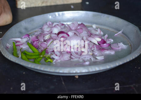 Mumbai, Inde - le 28 octobre 2015 - coupe femme piment et oignons sur un tabouret dans la coupe traditionnelle cuisine indienne Banque D'Images