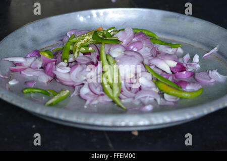 Mumbai, Inde - le 28 octobre 2015 - coupe femme piment et oignons sur un tabouret dans la coupe traditionnelle cuisine indienne Banque D'Images