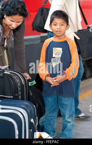 Florence, Italie. Caucasian woman aide avec ses bagages d'Amérique a adopté garçon à la gare Banque D'Images