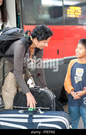 Florence, Italie. Caucasian woman aide avec ses bagages d'Amérique a adopté garçon à la gare Banque D'Images