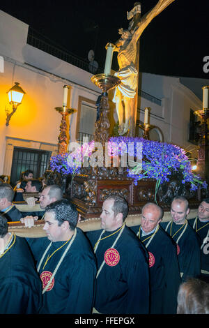 Des hommes forts portant le palanquin portant Jésus sur la Croix à travers les rues du village de Pâques (Semana Santa). Carcabuey, Cordoue, Andalousie.Espagne Banque D'Images