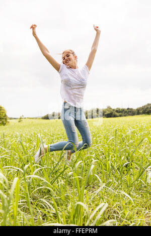 Happy teen girl jumping haut dans le champ de canne à sucre Banque D'Images