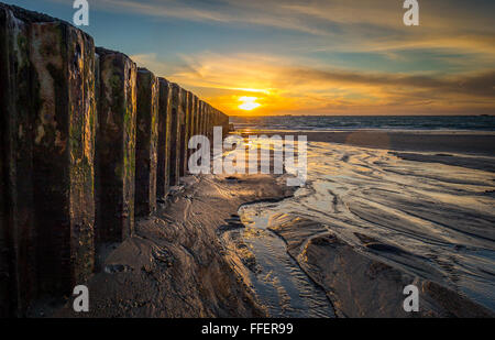 Coucher du soleil sur la baie de St Clements à Jersey. La lumière du soleil qui se reflète sur le magnifique sable humide et l'eau d'arrivée. Banque D'Images