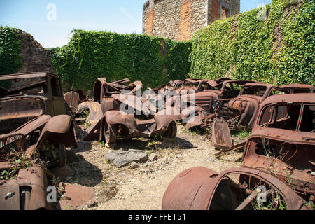 La rouille des voitures abandonnées dans le village d'Oradour sur Glane, Haute Vienne, France Banque D'Images
