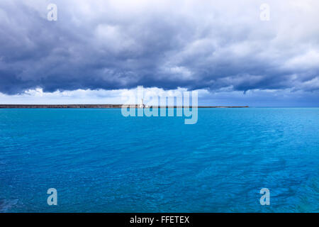 Port de Livourne phare, brise-lames et de l'eau sous le mauvais temps nuageux ciel. La Toscane, Italie, Europe. Photos à longue exposition. Banque D'Images