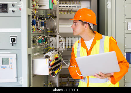 Contrôle de l'état du transformateur technicien informatique avec ordinateur portable Banque D'Images