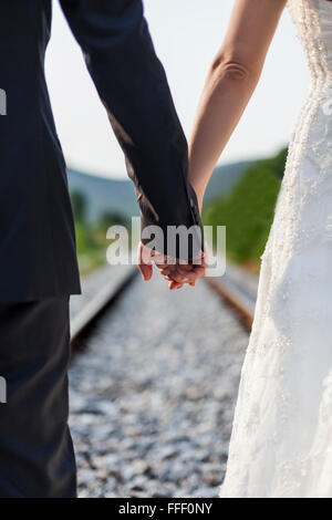 Les jeunes mariés ensemble en dehors dans la nature le jour de leur mariage en vertu de la lumière du soleil Banque D'Images