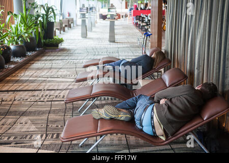 Épuisé,passagers,dormir,dormir,privé,le manque de sommeil, repos,sur,salon,chaises,lits,fournis,au départ,terminal,l'aéroport Changi de Singapour,Asie,,, Banque D'Images