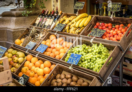 CORTONA, ITALIE - 26 juin 2015 : assortiment de fruits mûrs toscan et des bouteilles de vin dans la ville historique de Cortona en Italie Banque D'Images