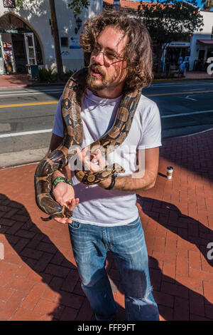 Propriétaire d'un serpent boa constrictor colombien ses rideaux autour de son cou alors qu'il montre le serpent pour piétons à collecter de l'argent. Banque D'Images