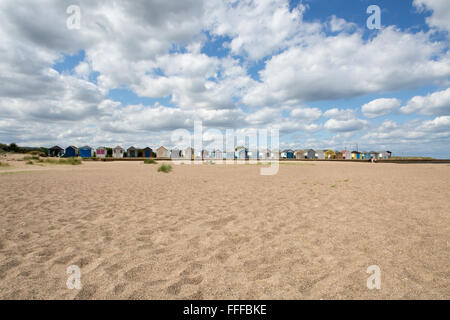 Rangée de cabines de plage traditionnel anglais avec beaucoup de nuages et de sable, Mer du Nord, Sutton-sur-Mer, Lincolnshire, Angleterre, RU Banque D'Images