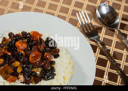 Riz végétarien avec des abricots secs et raisins gros plan sur la table. Banque D'Images