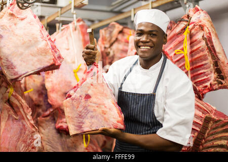 Smiling African remise dans l'abattoir de bovins de boucherie Banque D'Images