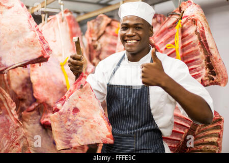 Happy African butcher holding la viande fraîche en boucherie Banque D'Images