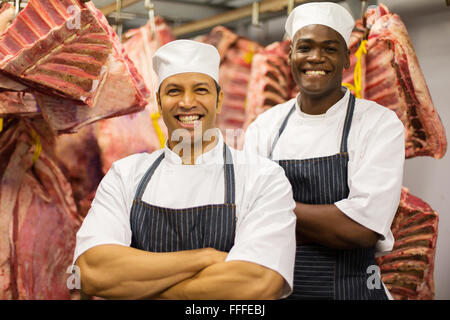 Portrait of happy homme debout devant les bouchers de viande crue Banque D'Images