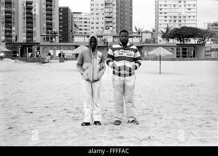 Jan 4, 2016 - South Beach, KwaZulu-Natal, Afrique du Sud - deux hommes se tenir en face de la plage du Club de sauvetage. South Beach est une partie de la ville de Durban sans interruption la plus longue étendue de plage de sable. La ville de Durban est sur la côte est de l'Afrique du Sud et les gens ici sont lavés avec de l'eaux chaudes de l'Océan Indien. Au nord de cette étendue de sable sont des plages avec la société hang out cafe. Au sud il y a une jetée avec le quartier haut Moyo's Restaurant à elle est la fin et l'uShaka Marine World et le secteur complexe de la mer et surf clubs de la plage les vesces. Entre Banque D'Images