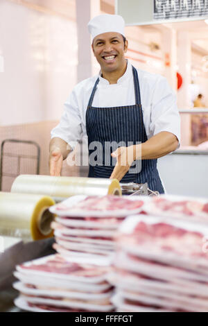 Homme heureux dans un conditionnement des viandes de boucherie boucherie Banque D'Images