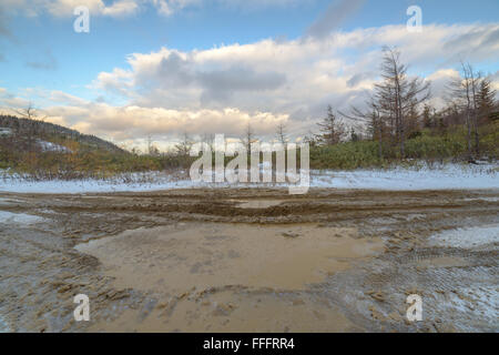 Une flaque d'eau sur un chemin de terre à la fin de l'automne, l'île de Sakhaline, en Russie. Banque D'Images