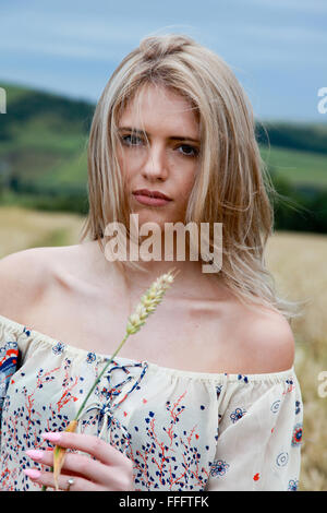 Portrait d'une belle jeune fille avec de longs cheveux blonds dans le vent à tout droit à l'appareil photo Banque D'Images