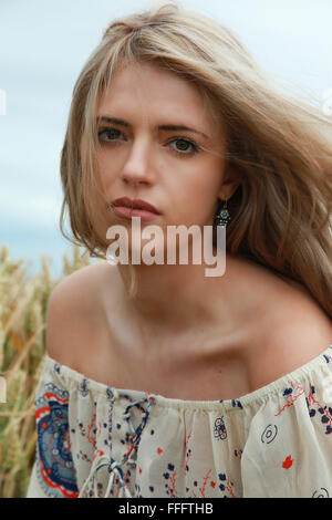 Portrait d'une belle jeune fille avec de longs cheveux blonds dans le vent à tout droit à l'appareil photo Banque D'Images