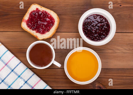 Tasse de thé pain avec de la confiture et du miel sur une table en bois. Vue d'en haut . Banque D'Images