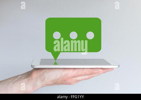 Hand holding smartphone avec l'icône messagerie vert Banque D'Images