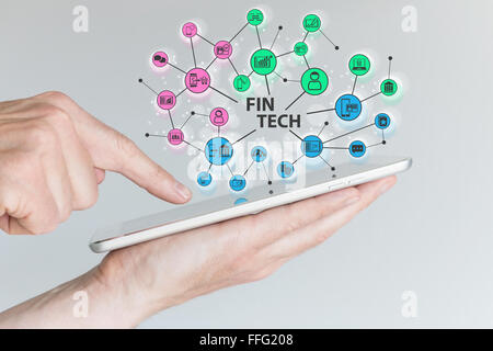 Fin Tech et l'informatique mobile concept. Hand holding tablet avec réseau de la technologie de l'information financière d'objets devant Banque D'Images