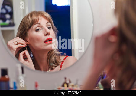 Young woman putting on d'oreille. Banque D'Images