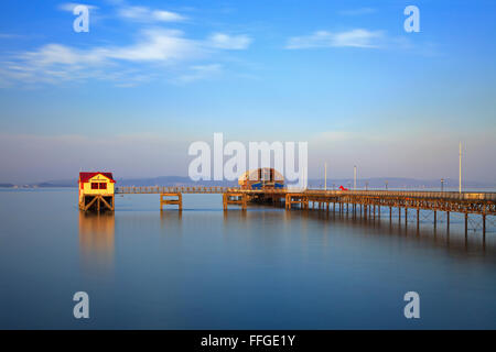 Mumbles Pier sur le côté ouest de la Baie de Swansea, sur la côte sud du Pays de Galles, baigné de lumière de fin de soirée à la mi-avril. Banque D'Images