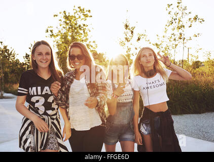 Groupe de filles rire et pose, à l'extérieur un jour d'été, sun flare Banque D'Images