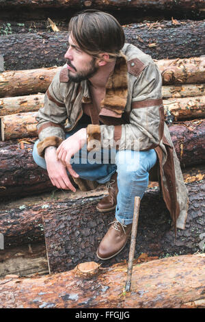 Les jeunes hommes sur des rondins dans la forêt. Cuir et jeans Banque D'Images