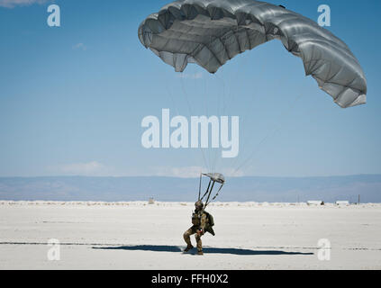 Airman Senior Pedro Rodriguez, un contrôleur de combat avec la 22e Special Tactics Squadron de Joint Base Lewis-McChord, dans l'État, des terres sur le White Sands Missile Range au Nouveau Mexique après avoir sauté 13 000 pieds d'un HC-130J Combattre King II. Un contrôleur de combat a pour mission de déployer inaperçus dans le combat et les environnements hostiles d'effectuer la reconnaissance spéciale, d'établir des zones d'agression ou d'aviation, tout en effectuant le contrôle de la circulation aérienne, l'appui feu, de commandement, de contrôle et de communication et de contrôle aérien avancé. Banque D'Images