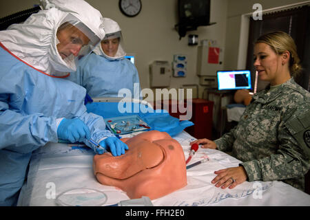 Le Major de l'armée américaine Heather Delaney observe alors que le colonel de l'US Air Force (Dr.) Bradley Lloyd insère une seringue dans une ligne centrale formateur pendant un cours de formation d'une semaine au Centre médical militaire de San Antonio, Texas. Lloyd fait partie d'une équipe de 30 membres établi par le Secrétaire de la Défense pour répondre à une éventuelle épidémie d'Ebola dans le United States Banque D'Images