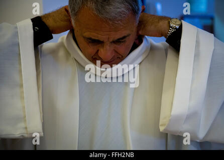 Aumônier à la retraite (Lt. Le colonel) Robert Bruno ajuste son alb blanc avant d'entrer dans le dortoir chapelle pour la prière du matin. L'alb est l'investissement commun pour tous les ministres lors de la messe. Banque D'Images