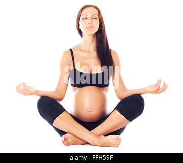 Femme enceinte assise en tailleur et faisant du yoga Banque D'Images