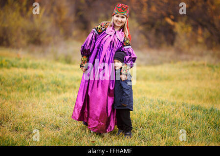 Portrait de famille de la mère avec son fils à l'extérieur dans un costume national. Couleurs d'automne, des ornements d'Asie. Banque D'Images