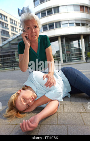 Hauts femme faisant appel d'urgence pour l'ambulance Banque D'Images