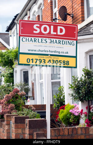 Le marketing pour vendre les panneaux de l'agent immobilier local Charles Smith à l'extérieur des maisons sur une rue de Swindon Wiltshire, UK Banque D'Images