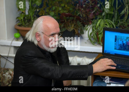 Portrait of senior homme chauve barbu gris noir en costume d'affaires travaillant sur ordinateur portable. Banque D'Images