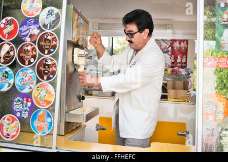 Un homme dans un distributeur van faisant un whippy cornet à partir d'une machine Banque D'Images