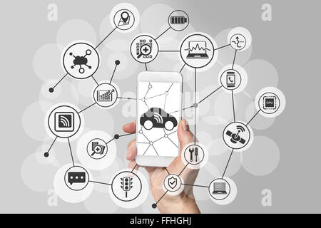 Connecté car concept with hand holding smart phone moderne en face de fond neutre. Banque D'Images