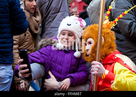 Londres, Royaume-Uni. 14 février 2016. Une jeune personne prend un avec le singe selfies en costume traditionnel pendant le Nouvel An chinois 2016 défilé dans le centre de Londres. Des interprètes costumés ont participé au défilé le long de Charing Cross Road et du quartier chinois, avec d'autres célébrations dans Trafalgar Square. L'événement est organisé par l'Association chinoise de Chinatown de Londres. Credit : Dinendra Haria/Alamy Live News Banque D'Images