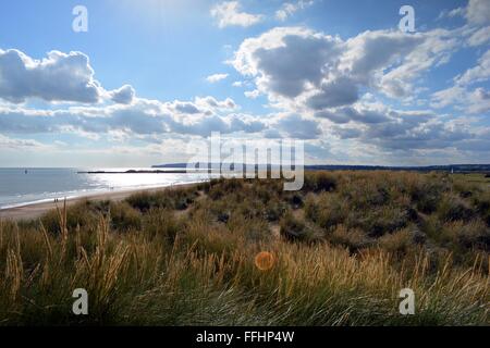 Les dunes de sable et une mer étincelante à Camber Sands dans le Sussex, England, UK Banque D'Images