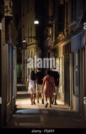 Un groupe de touristes se promener dans l'une des rues commerçantes étroites de Venise, dans le nord de l'Italie Banque D'Images