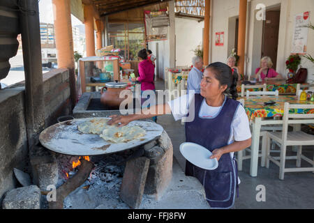 Matatlán Santiago, Oaxaca, Mexique - un travailleur fait le grand restaurant typique d'Oaxaca les tortillas sur un comal. Banque D'Images